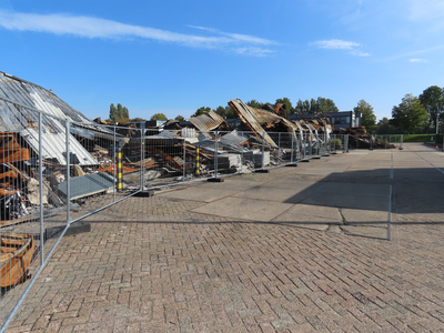 912108 Gezicht op de verwrongen metalen restanten van het uitgebrande bedrijfsverzamelgebouw Strijkviertel 35 te De ...